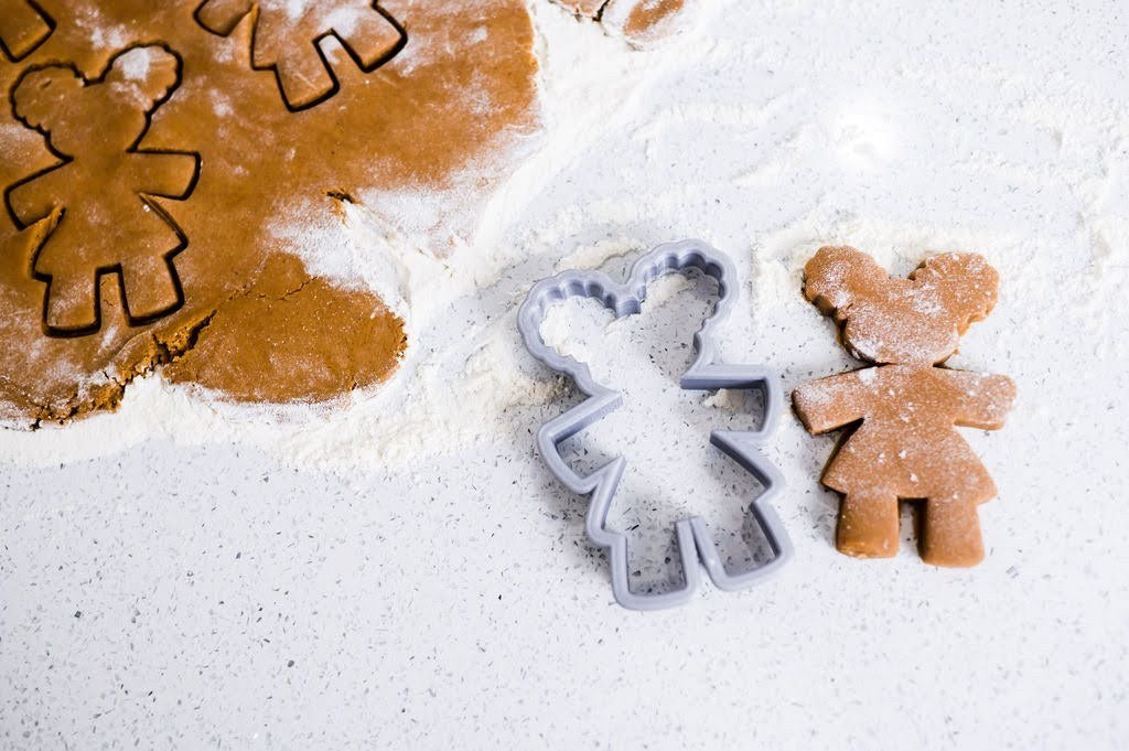 Gingerbread Diva cookie cutter beside a freshly cut Diva cookie